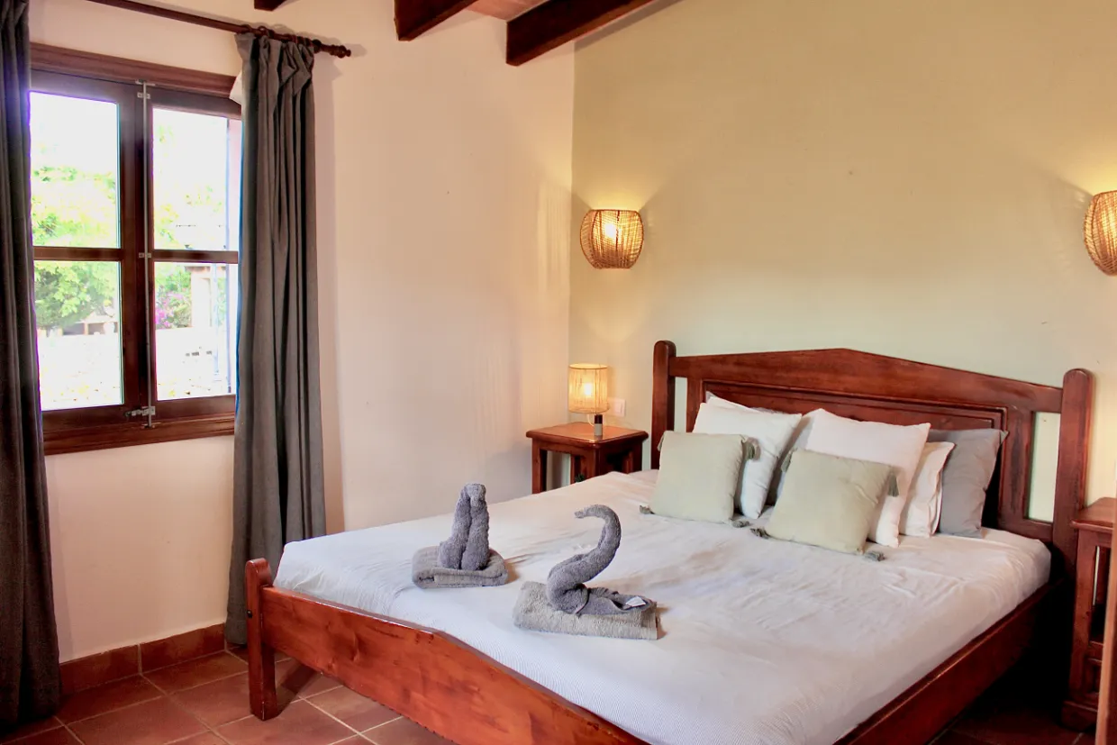 Dormitorio de matrimonio con vigas de madera noble
